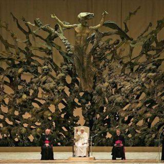 Pope Benedict XVI (C) waves to the faithful, flanked by Archbishop James Michael Harvey (L) and his personal secretary Georg Genswein (R), during his weekly Wednesday general audience at Paul VI Hall at the Vatican August 24, 2005. REUTERS/Alessandro Bianchi